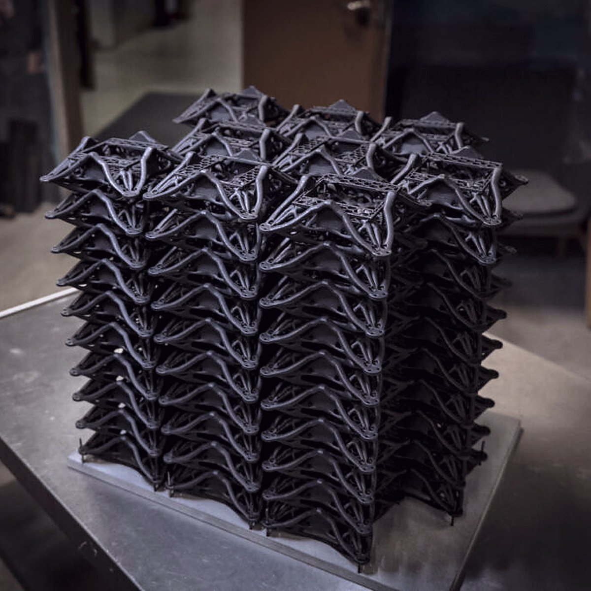 A full batch of identical printed parts stacked on the bench